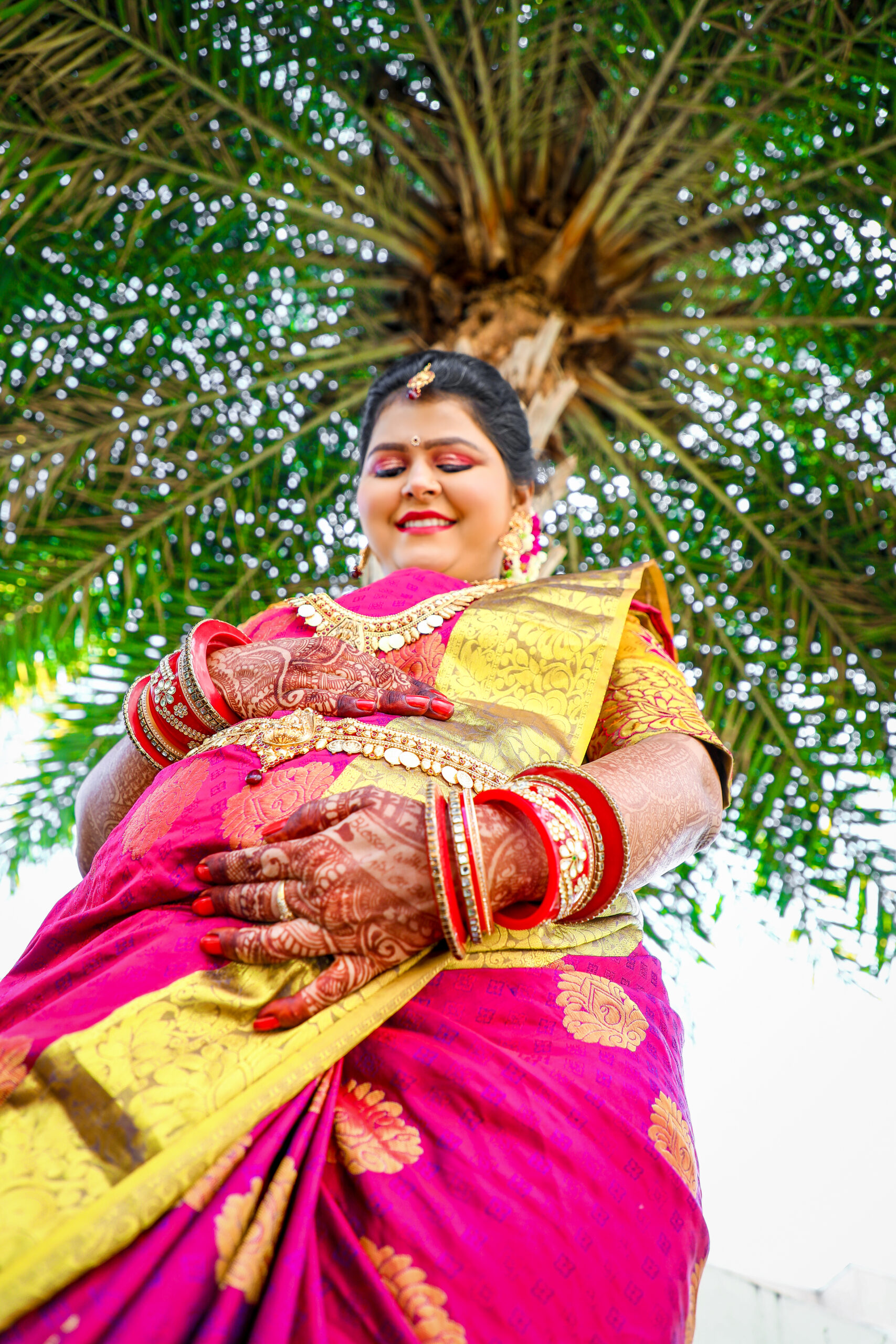 1. A smiling woman in a colorful sari poses for the camera during Gayathri's Maternity Photoshoot by ak photography coimbatore.