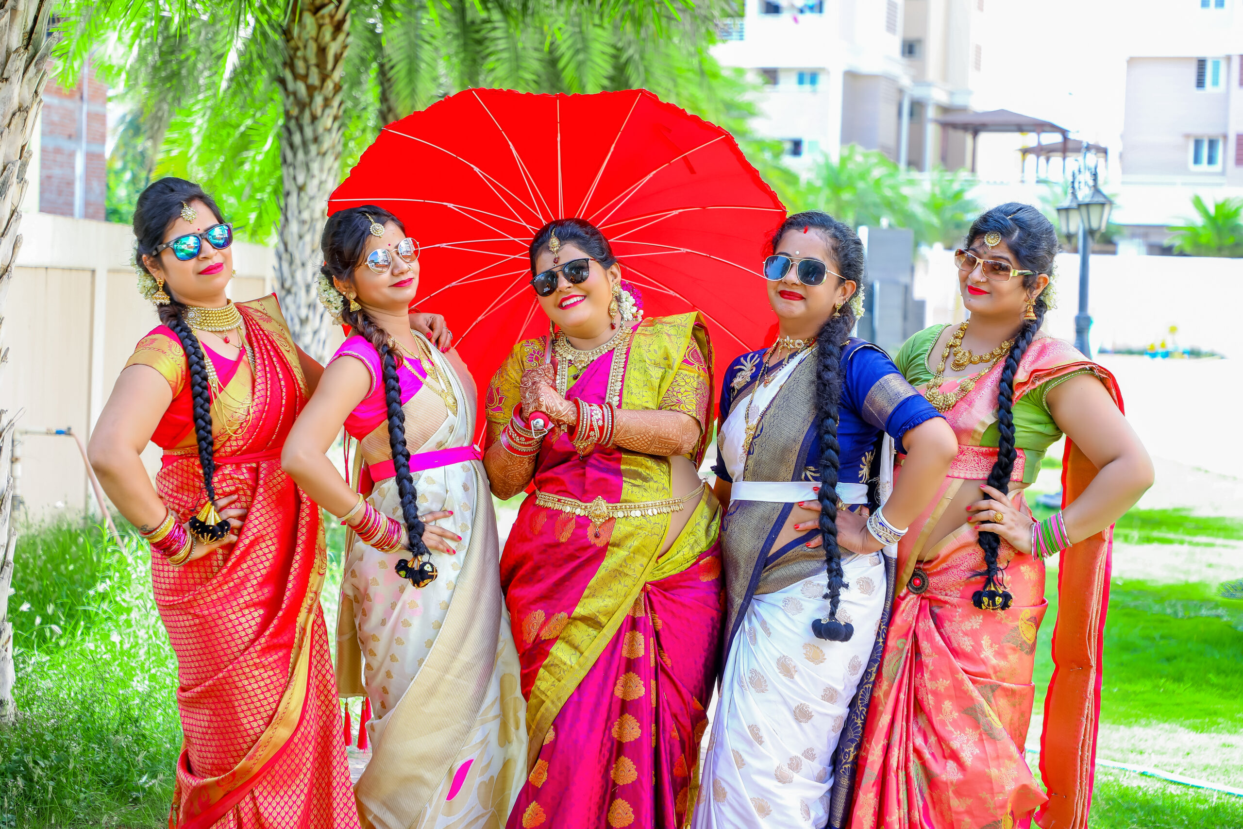 A vibrant group of women in colorful saris, radiating joy and elegance during Gayathri's Maternity Photoshoot by AK Photography Coimbatore
