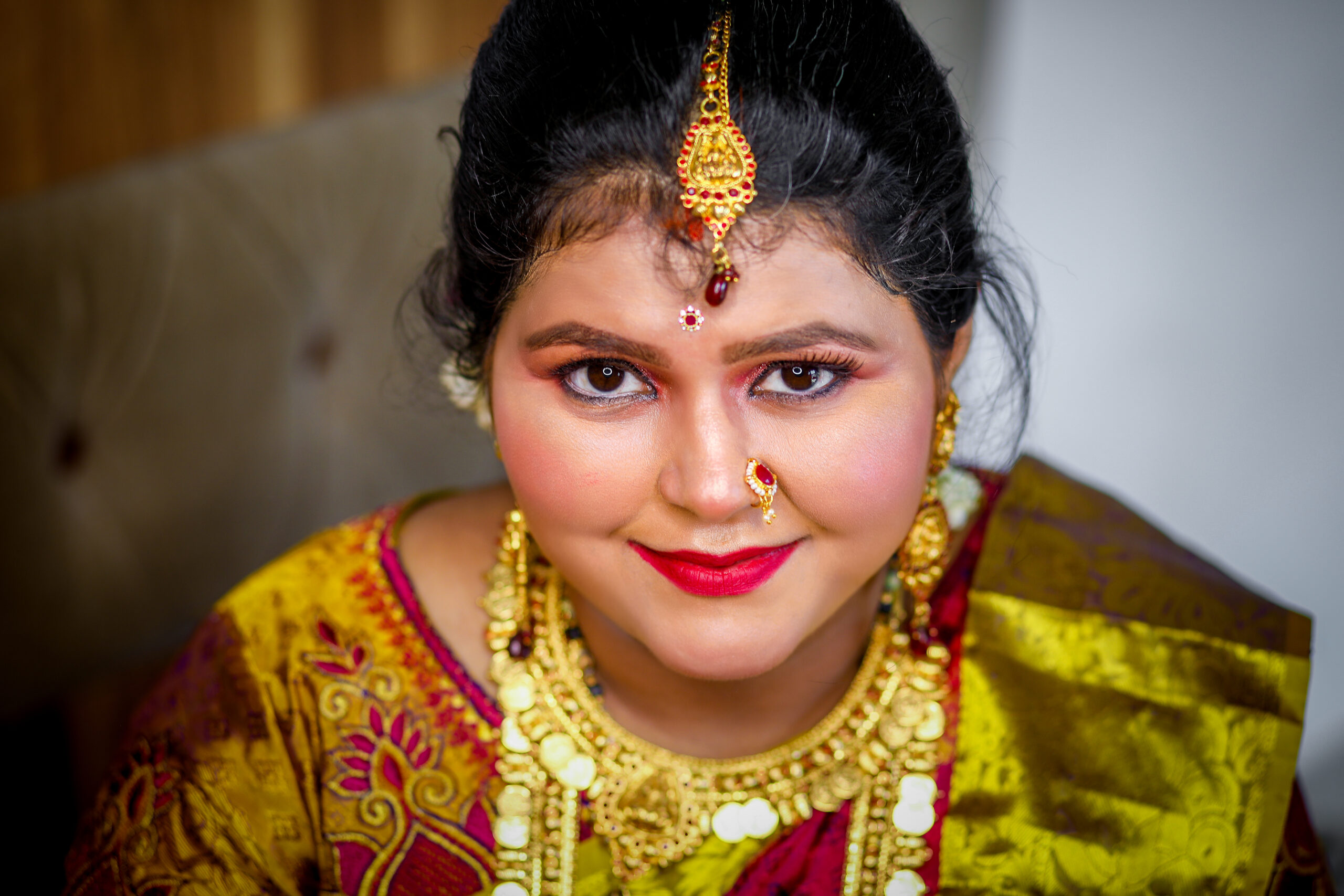 A smiling woman in traditional Indian attire, radiating joy and beauty.