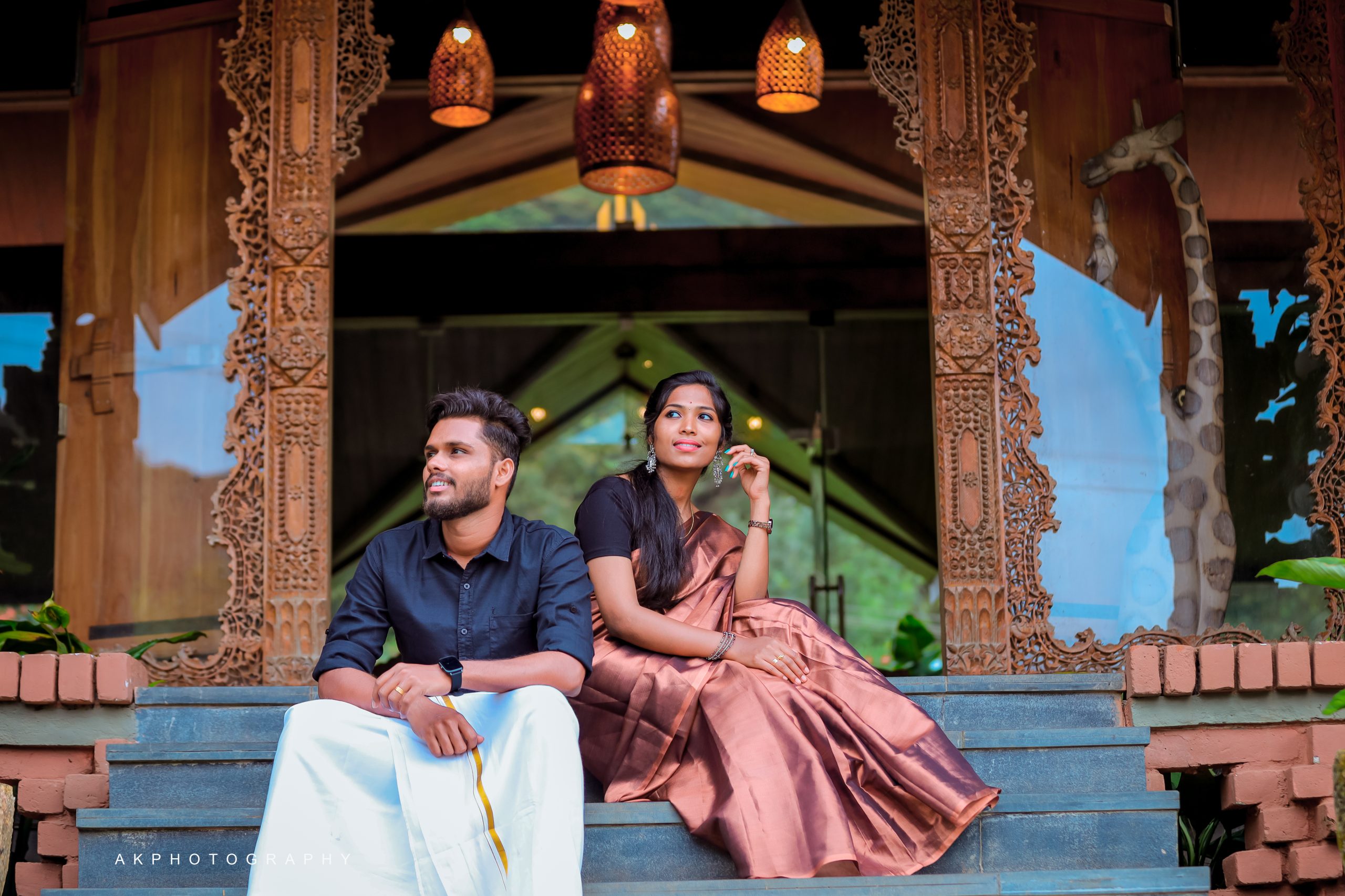 An indian couple sitting on the steps of a house. Enchanting Pre-Wedding Couple Shoot of Krishna & Nivetha in Ooty,
