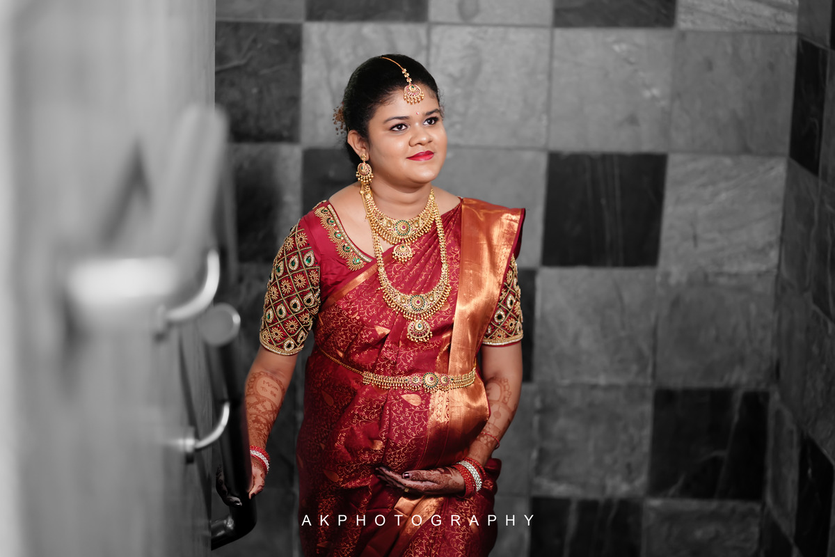 A stunning Indian bride in a red sari, captured during a Baby Shower Photoshoot by AK Photography.