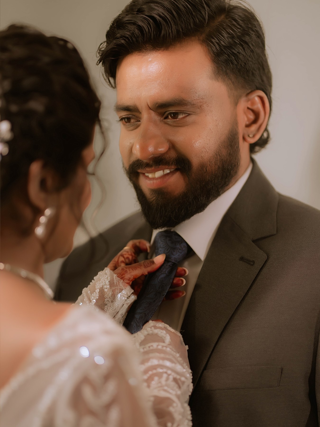 Bride Darthy gently adjusting groom Rumanes tie in an affectionate candid wedding moment in Coimbatore