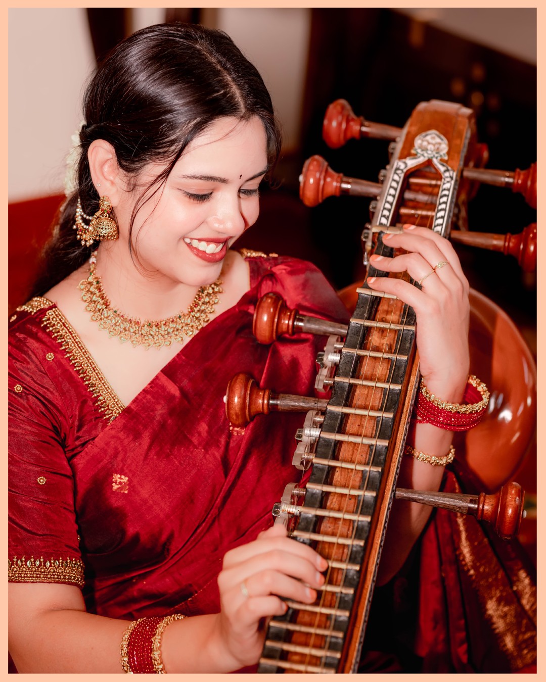 Solo bridal portrait of Sneha holding Saraswati Veena in traditional Kanchipuram silk saree