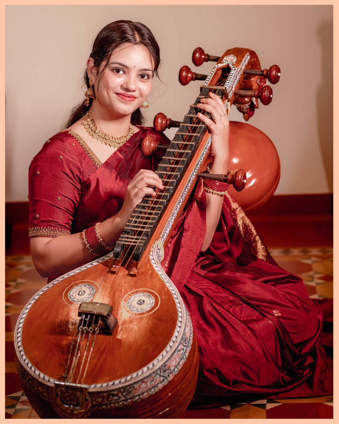 Close-up artistic portrait of bride Sneha with Saraswati Veena highlighting temple jewellery and expressive eyes