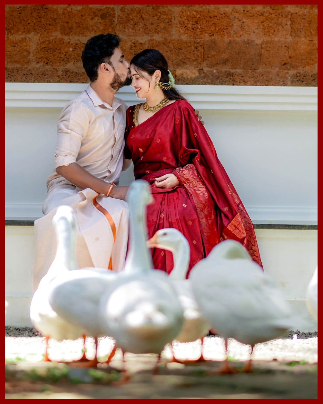 Romantic forehead kiss of Sneha and Deepak against antique swan wooden carvings at Kurumboor Mana Palace