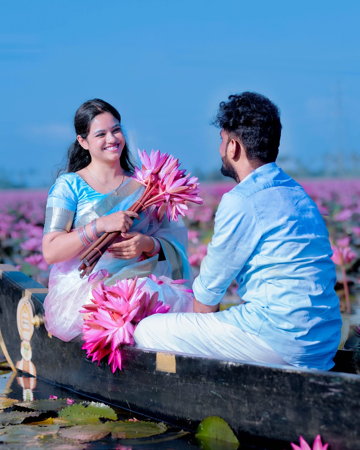 Romantic wooden boat pre-wedding shoot of Shneka and Deepak surrounded by blooming water lilies at Malarikal by AK Photography