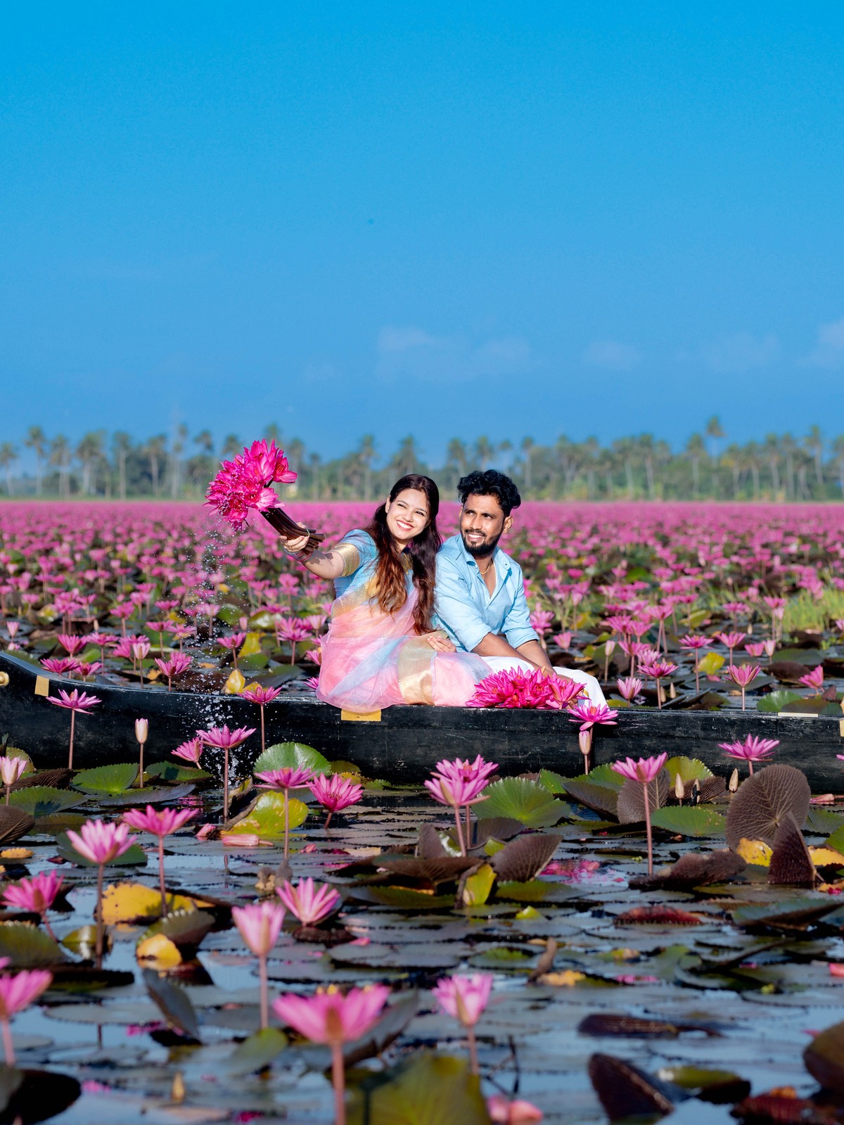 Playful water lily bouquet portrait of Shneka and Deepak on boat at Malarikal by AK Photography Coimbatore