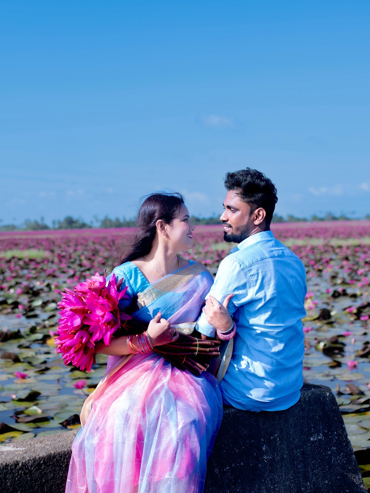 Romantic stone bridge bund portrait of Shneka and Deepak overlooking vast water lily lake in Malarikal Kerala